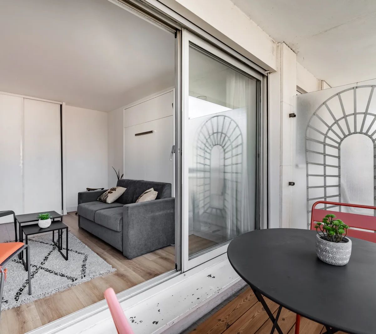 Appartement moderne rénové avec salon ouvert sur terrasse, mobilier contemporain et grande baie vitrée