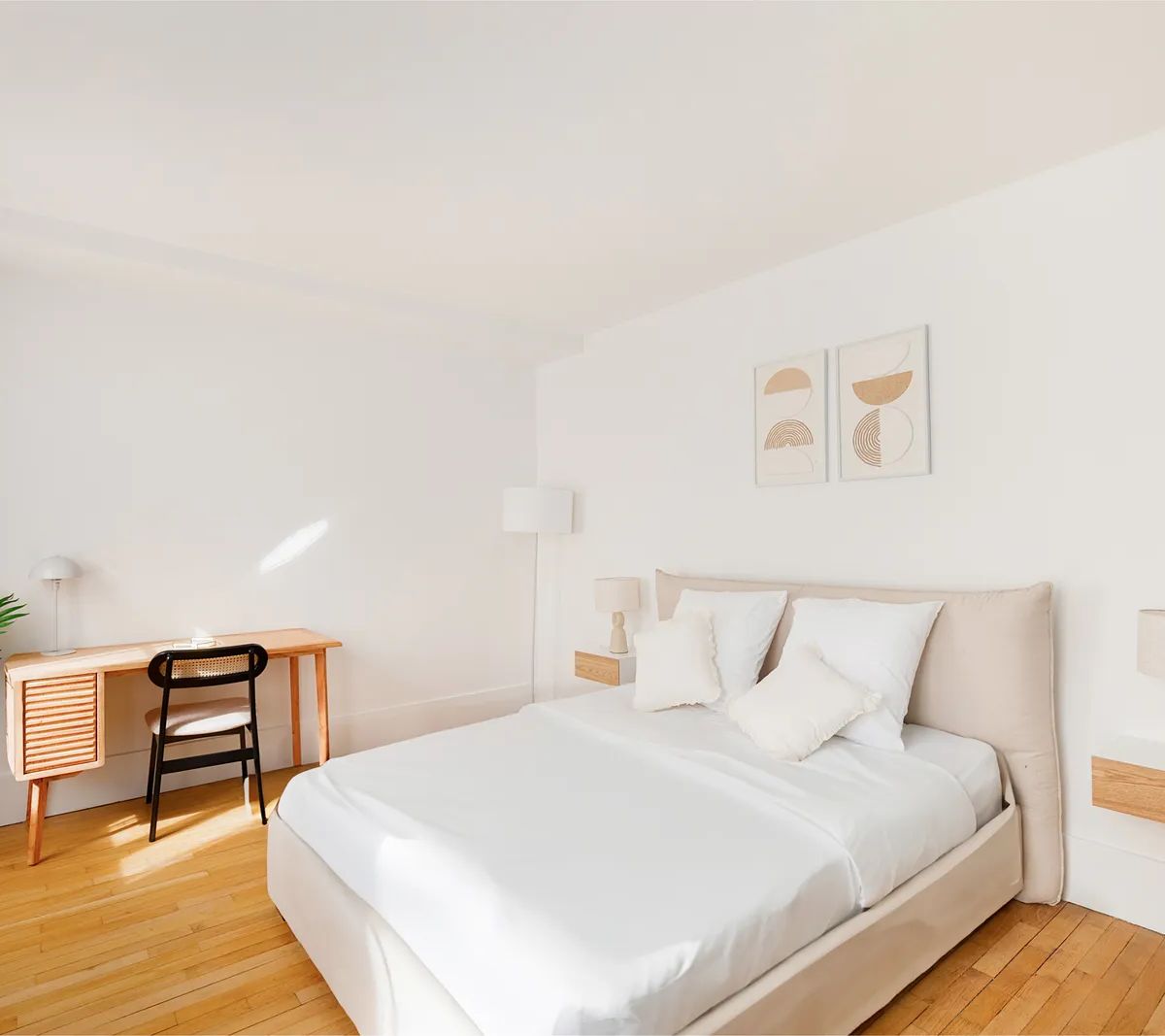 Chambre moderne avec parquet bois, lit beige, bureau scandinave et décoration minimaliste aux tons neutres
